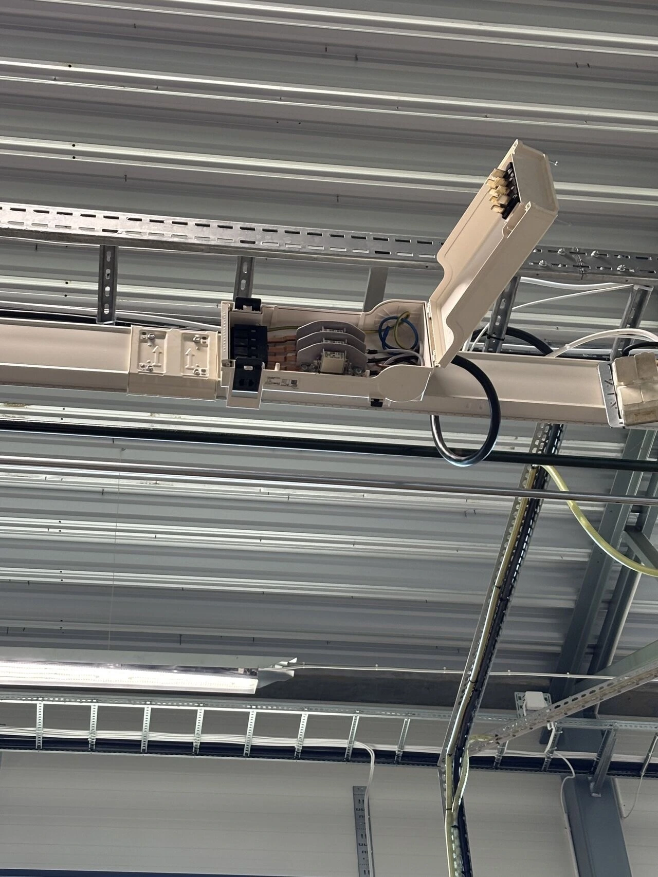 Kopplingsbox monterad i tak med kablar anslutna till kabelstege i industrifastighet – AE Elteknik