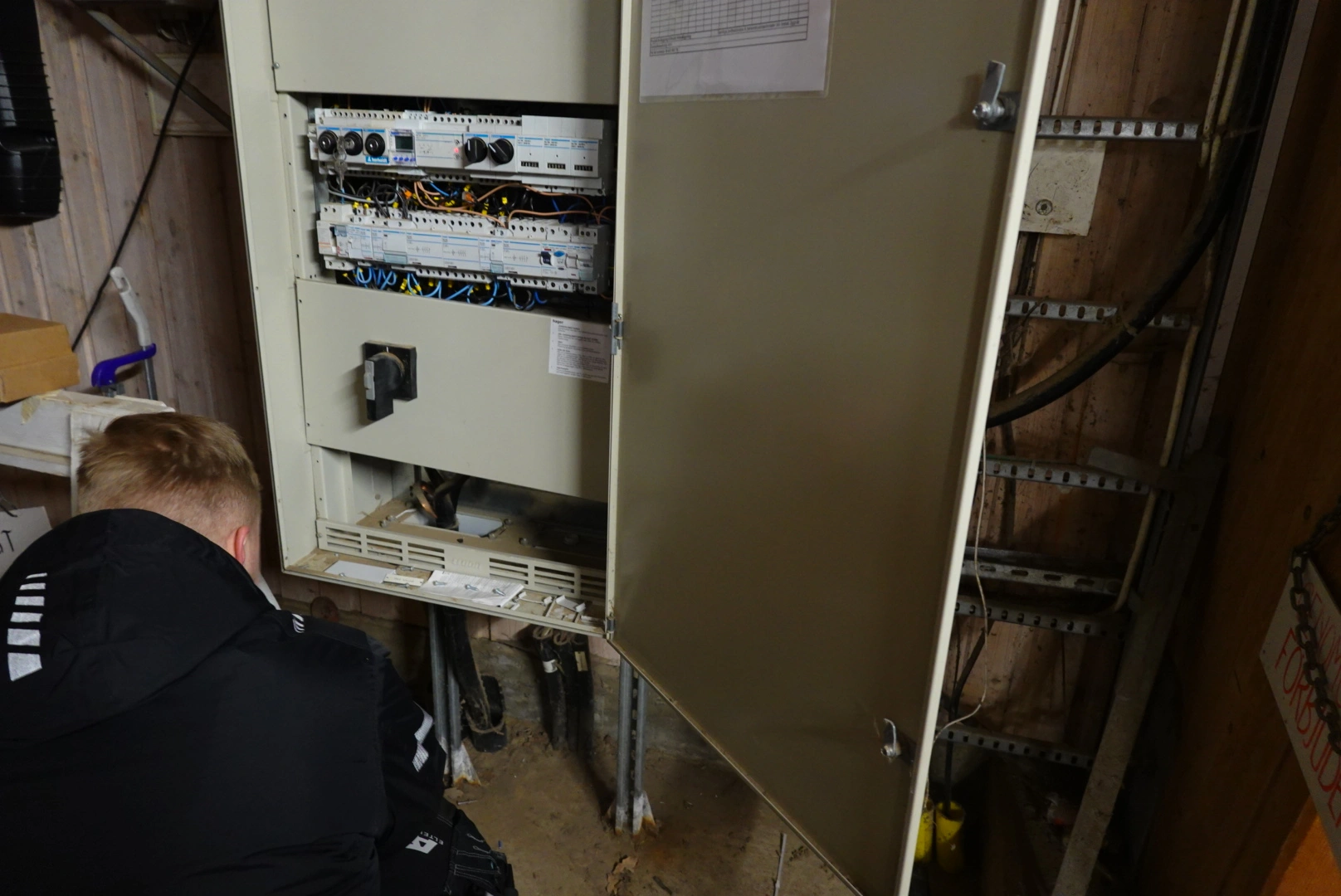 Elektriker inspekterar elskåp med självtestande jordfelsbrytare i fastighet – AE Elteknik